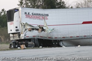 The contents of a tractor-trailer rig can be seen through a gash in the side of the trailer.