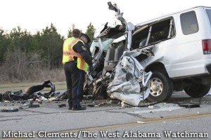 Demopolis Police and Alabama State Troopers survey the damage to a van involved in an accident on Highway 80.