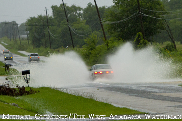 A car travelling north on Jefferson Road near the Industrial Park sends a blanket of water flying.
