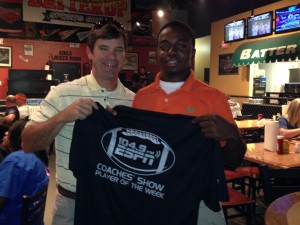 ESPN 104.9 Coaches Show host Rob Pearson presents a commemorative T-shirt to Marengo High senior running back and linebacker Jatevin Horn at Batter Up Sports Grill in Demopolis Tuesday night. Horn was the show's Player of the Week. 