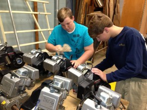 Austin Barton (left) and Chandler Barton clean some of the 32 engines donated by Auburn University to Demopolis High School Agriscience Education.