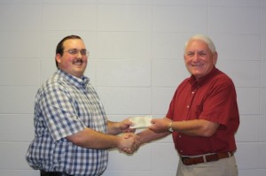 Demopolis High FFA sponsor Trent Wells receives a donation from Marengo County Farmers Federation president Meador Jones.