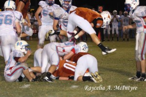 (Photo courtesy Raycelia McIntyre)  Ralph Langley leapfrogs the pile to avoid a late hit.