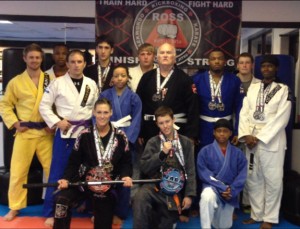Team photo - Pictured are members of the Ross Martial Arts Fight Team (left to right): Front row - Ronda Russell, Brett Schroeder, Dre Pruitt; Second Row - Daniel Alexander, A.J. Pruitt, Jay Russell, Tristen Fitz-Gerald, Makiyha Lewis, Anthony Baze, Ron Ross, Franklin Richardson, Ethan Garrick, Nikki Smith. Not pictured are Collin Morgan and Matt Trest.
