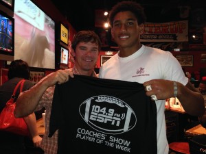 Demopolis senior Demetrius Kemp receives a commemorative Player of the Week T-shirt from ESPN 104.9 Coaches Show co-host Rob Pearson Tuesday night at Batter Up Sports Grill.