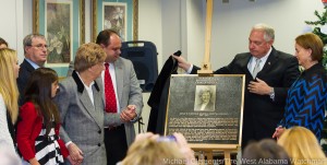 Arthur Evans unveils the plaque honoring Mrs. Edith Whitfield's many years of service as a Charter Member of the Bryan W. Whitfield Memorial Hospital Auxiliary.  Mrs. Whitfeild was joined by several of her family members.