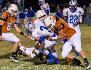 Brant Lewis (34) and Hayden Hall bring down a Chambers Academy runner as Thomas Etheridge (62) closes in.