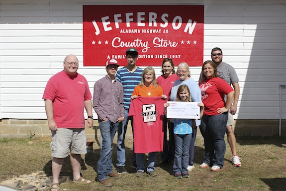 Pictured left to right at Jefferson Country Store are George Patterson, Bigbee Volunteers Dakota Cunningham, Cindy McDonald (holding a Store Dog shirt) Tommy Hewitt, Donna McPherson and Martha Ellis, with Jefferson Country Store owners Betsy Compton, Tony Luker, and Mary Sam Luker (holding check). Not pictured: Store Dog 1