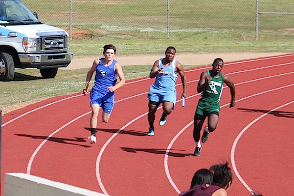 Logan McVay sprints the third leg of the boys' 4x100-meter relay.