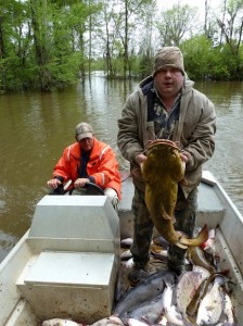 Phillip Roberts shows off the big catch of the day, a 30-plus-pound flathead catfish as James Hall looks on.