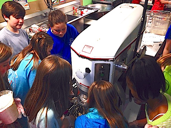 U.S. Jones fifth grade enrichment students crowd around the mixer in the school cafeteria to prepare cookie dough.