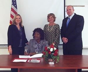 Hale County Schools Superintendent Osie Pickens signs the system's UWA Teacher Connect agreement to provide lowered tuition rates for teachers within the system who wish to pursue advanced degrees. Pictured with Pickens are (left to right, standing), Dr. Kathy Chandler, dean of Online Programs and the Julia S. Tutwiler College of Education; UWA Online Recruiting Director Lisa Compton; and Online Admissions Counselor Byron Thetford.