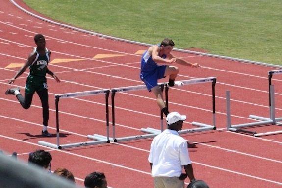 Logan McVAy competes in the 300-meter hurdles.