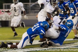 A.J. Collier (21) and Rahmeel Cook (44) bring down a Jemison High School ball carrier.