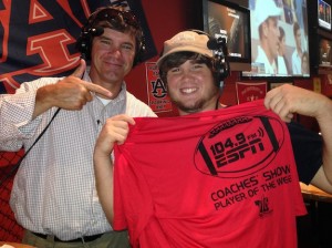 ESPN 104.9 co-host Rob Pearson presents Tyler Colburn of Demopolis High School with a commemorative Player of the Week T-shirt during Tuesday's broadcast at the Batter Up Sports Grill.