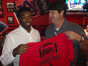 Marengo High senior Floyd Simmons receives a commemorative Player of the Week T-shirt from ESPN 104.9 crew member Sean Parker.