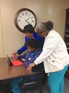 Bryan Whitfield Home Health Division Director Marcia Pugh and staff members Cassandra Glover and Annie Jones work with one of the department’s new Point of Care nursing documentation tablets.