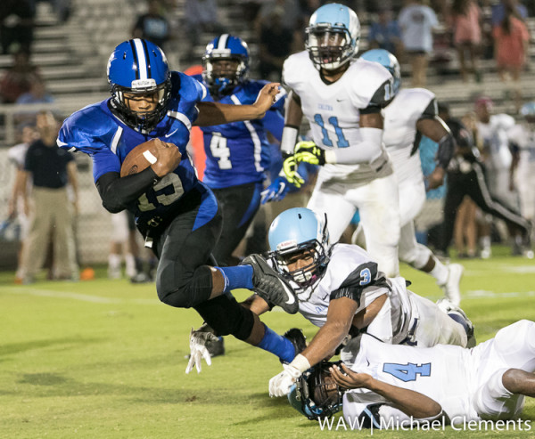 Demopolis' Jamarcus Ezell (15) gets tripped up by two Calera defenders.