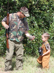 Grant Barnhill and his dad, Kevin, examine a dove downed during the opening weekend of dove season at Gulf Farms near Orrville, Ala. (Photo by David Rainer)