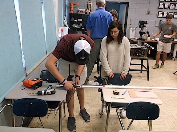 Jake Jacobs and Tori Horne cut pvc pipe for the robot.