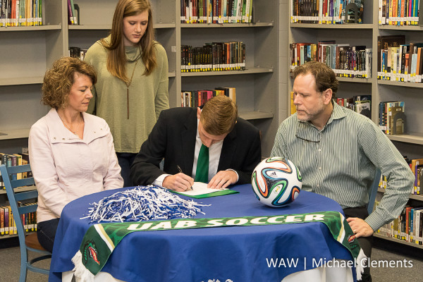 Adam Brooker (seated, center) signs to play soccer at UAB as his mother, Diane, sister, Madelyn and father, Brian, look on. 