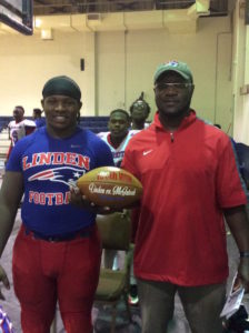 Linden coach Andro Williams along with Brandon Bates following the 100th win of his career, a 69-0 victory over McIntosh.