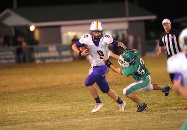 (Photo by Johnny Autery) A determined QB Jonah Smith (9) drives hard to pull away from a Millry tackler.