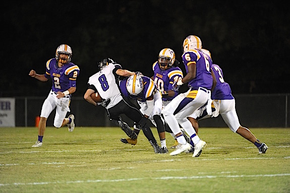 (Photo by Johnny Autery) DB Will Huckabee (11) puts a shoulder into the Pirate WR as additional bulldogs converge on the play.