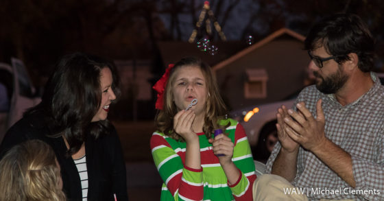 11-30-2016 -- Demopolis, Ala. -- Camilla Smith (center) blows bubbles with her parents, Kelley (left) and Brandon Smith, before she threw the breaker to light the Love Light Tree at Bryan W. Whitfield Memorial Hospital on Wednesday night. This event kicks off the 2016 Christmas on the River events in Demopolis.