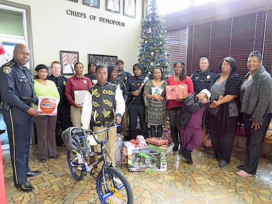 Monroe Reese Jr. (12) along with his aunt Canary Howard and her daughter Chloe (9) receive Christmas gifts from the Demopolis Police Department.