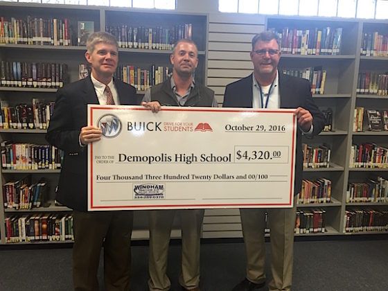 Blaine Hathcock (left) receives a check from Windham Motor Company's Tyler Windham. Chris Tangle (right) tendered his resignation effective Dec. 31. Hathcock will move from his post as principal of Demopolis Middle School to the interim DHS principal position.